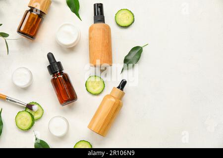 Composizione con prodotti cosmetici naturali e cetriolo su fondo chiaro Foto Stock