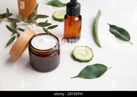 Prodotti cosmetici naturali, ingredienti e foglie di pianta su sfondo chiaro Foto Stock