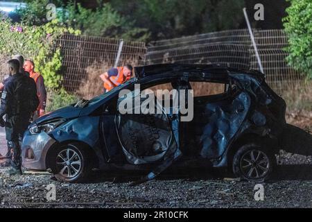 Ashkelon, Israele. 10th maggio, 2023. Gli ufficiali di sicurezza israeliani ispezionano un veicolo danneggiato dopo che una casa è stata colpita da razzi lanciati dalla striscia di Gaza. I militanti palestinesi nella striscia di Gaza hanno sparato diversi razzi contro Israele, in seguito agli scioperi israeliani che hanno colpito l'organizzazione militante islamica della Jihad nella striscia costiera. Credit: Ilia Yefimovich/dpa/Alamy Live News Foto Stock