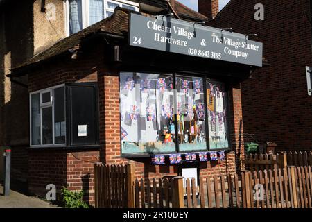 Cheam Village hardware Store con Bunting in Window festeggia il re Charles III incoronazione Cheam Surrey Inghilterra Foto Stock