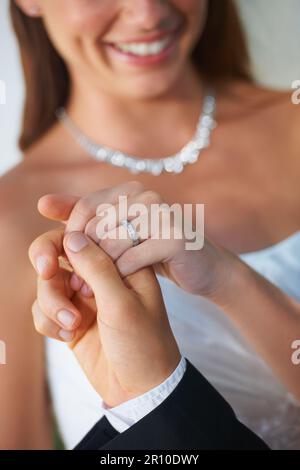 Prendendo la mano di sua moglie. Primo piano di uno sposo che conduce la sua sposa fuori dalla cappella - Focus on Wedding Ring. Foto Stock