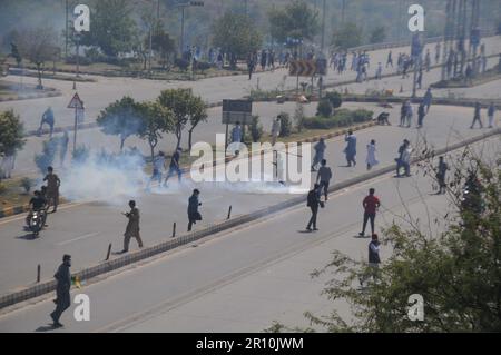 Islamabad, Pakistan. 10th maggio, 2023. Le forze di sicurezza pakistane sparano i proiettili di gas lacrimogeno verso i sostenitori del Pakistan Tehrerk-e-INSAF (PTI) durante uno scontro vicino al quartier generale della polizia, dove l'ex primo ministro Imran Khan è tenuto in custodia dopo il suo arresto a Islamabad. Khan è stato arrestato presso la sede dell'alta Corte di Islamabad a Islamabad il 09 maggio in un caso di corruzione, comparirà in un tribunale speciale presso il quartier generale della polizia della capitale per rispondere all'accusa di innesto. (Credit Image: © Raja Imran/Pacific Press via ZUMA Press Wire) SOLO PER USO EDITORIALE! Non per USO commerciale! Foto Stock