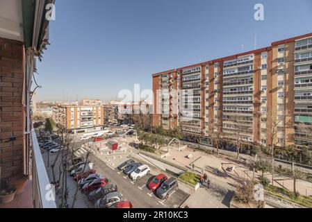 Facciate di edifici in una grande area aperta con parcheggi e parcheggi Foto Stock