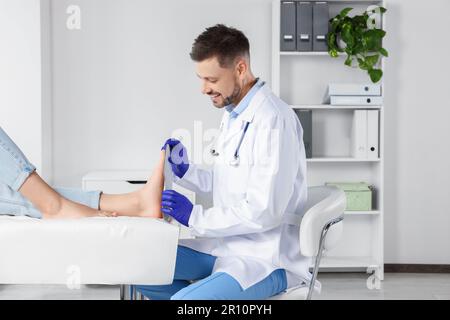 Soletta ortopedica maschile che si adatta al piede del paziente in ospedale Foto Stock