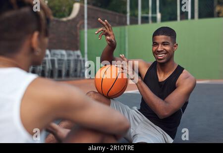 Impegnato nel gioco. due giovani sportivi che si chiacchierano tra loro in un campo da basket. Foto Stock