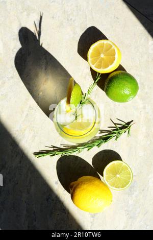 Gustosa limonata rinfrescante e ingredienti su tavolo grigio chiaro, piatto. Drink estivo Foto Stock