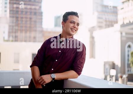 Un sogno non diventa realtà attraverso la magia. un giovane uomo d'affari in piedi fuori sul balcone di un ufficio. Foto Stock