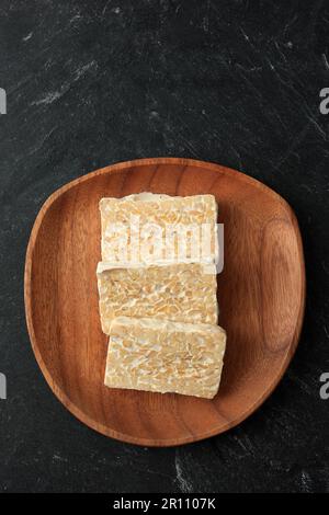 Top View Raw tempeh o Tempe Slice. Tempe a base di soia fermentata. Copia spazio per testo Foto Stock