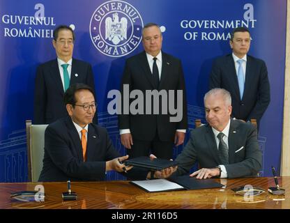 Bucarest, Romania. 10th maggio 2023: Il primo ministro sudcoreano Han Duck-soo (L) e Nicolae Ciuca (C) partecipa alla cerimonia di firma del Memorandum of Understanding tra l'amministrazione dei porti marittimi SA Constantza. E l'autorità portuale sudcoreana Busan dopo il loro incontro ufficiale al Palazzo Victoria, sede del governo rumeno, a Bucarest. Credit: Lucian Alecu/Alamy Live News Foto Stock