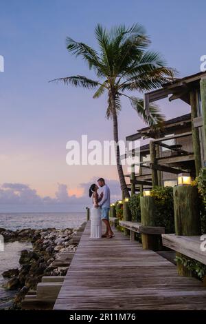 Coppia sulla spiaggia di Curacao durante il tramonto, uomini e donne che guardano il tramonto sulla spiaggia tropicale di Curacao durante le vacanze nei Caraibi Foto Stock