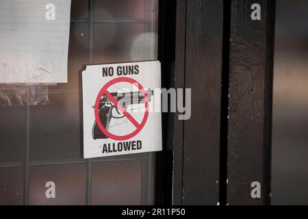 Nogales, Arizona, USA - 29 maggio 2022: Un adesivo su una porta d'affari comunica che non sono ammesse pistole nell'edificio. Foto Stock