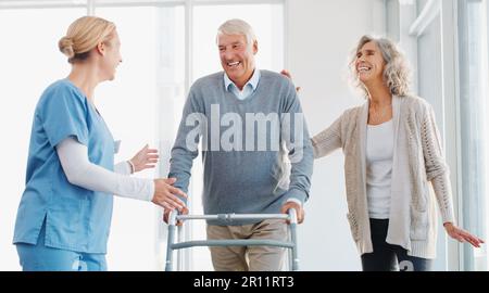 Dandogli la cura che merita. un uomo anziano che usa un camminatore con l'assistenza di sua moglie e di sua giovane infermiera. Foto Stock