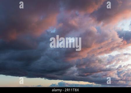 Una natura che stupisce: sfondo drammatico e moody rosa, viola e blu NUVOLOSO TRAMONTO sky shot verticale. Foto Stock