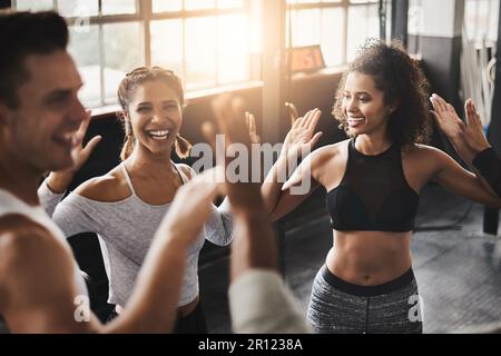 Niente solleva gli spiriti come l'esercitazione. un gruppo di giovani che si allenano insieme in palestra. Foto Stock