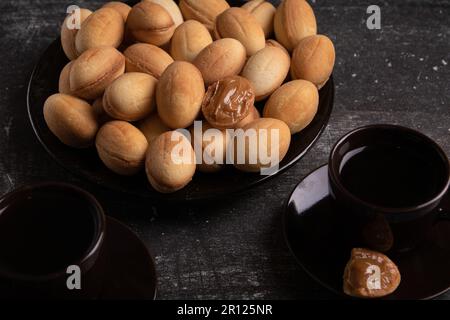 foto piatto completo di biscotti frollini con latte condensato sul tavolo Foto Stock