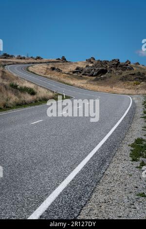 Curva a S sulla strada vicino a Ophir, Ida Valley, Central Otago, South Island, Nuova Zelanda Foto Stock