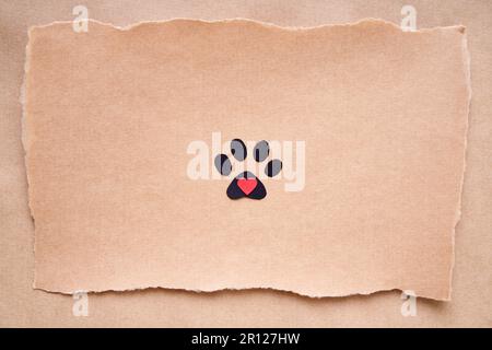 Cartolina con icona di stampa della zampa e cuore, stile di arte della carta. Concetto di amore animale, biglietto di auguri, mockup invito. Disposizione piatta, vista dall'alto, spazio di copia Foto Stock