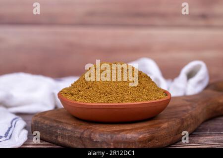 Cumino macinato o polvere di Jeera. Polvere di cumino spezia in ciotola su sfondo di legno. Concetto di spezie secche Foto Stock