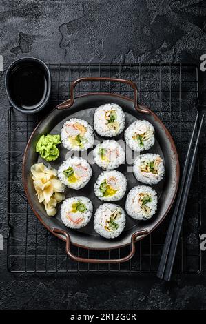 Gimbap Kimbap ripieno di verdure, uova, acciughe e granchio, rotolo di riso coreano. Sfondo nero. Vista dall'alto. Foto Stock