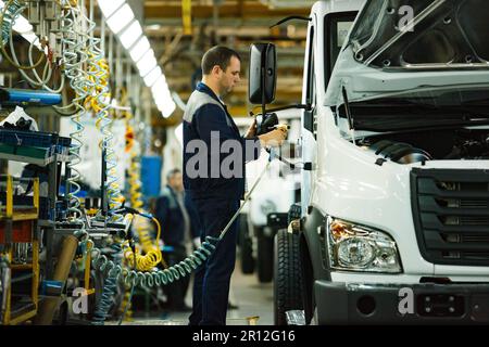 Nizhny Novgorod, Russia - 21 novembre 2020: Stabilimento di produzione auto DI GAZ. Operatore addetto all'assemblaggio degli specchietti Foto Stock