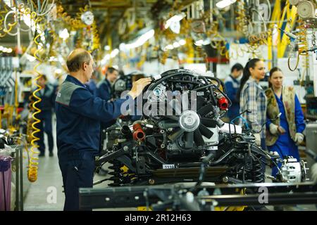 Nizhny Novgorod, Russia - 21 novembre 2020: Stabilimento di produzione auto DI GAZ. Lavoratori sulla linea di trasporto. Installazione del motore dell'autocarro Foto Stock