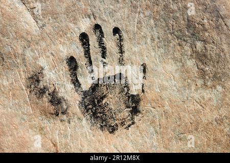 Stampa a mano su pietra arenaria. Impronta umana sulla parete. Primo piano di handmark. Segno antico. Stampa in bianco e nero. Concetto di identità. Arte tribale Foto Stock