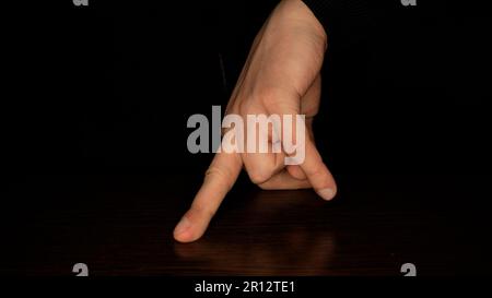 Dita maschili che ballano su uno sfondo scuro. Divertimento e concetto di teatro. Foto Stock