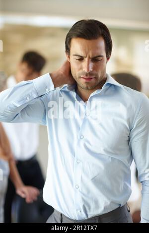 Il mio collo mi uccide. un uomo d'affari che tiene sul collo dolorante mentre è in ufficio. Foto Stock
