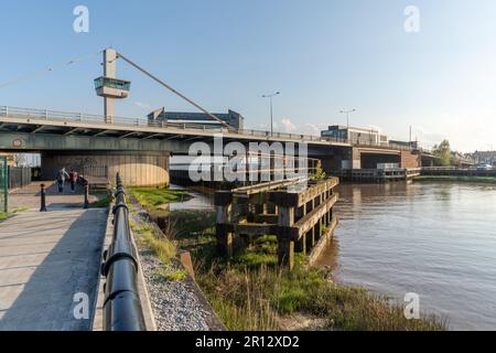 Una vista sul fiume di Tower Street, Kingston upon Hull, Regno Unito, passando sotto la strada A63 della città, con due persone che fanno una passeggiata. Foto Stock