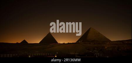 Le piramidi di Giza si illuminano durante lo spettacolo di suoni e luci per celebrare il Festival Ramadan del Cairo, in Egitto. piramidi di Cheope e Chefren e mykeri Foto Stock