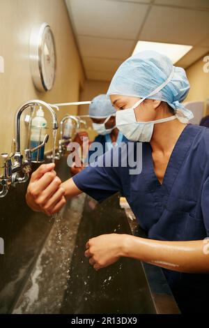 Procedura di preparazione per i pazienti. un team di chirurghi che sterilizzano braccia e mani come parte di una routine chirurgica. Foto Stock