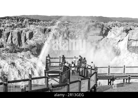 Augrabies National Park, Sudafrica - 25 2023 febbraio: Turisti in un punto di vista presso la cascata principale Augrabies nel fiume Orange. Il fiume è in floo Foto Stock