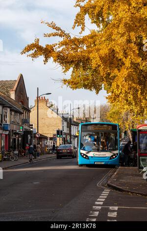 Autunno su Mill Road Broadway, Cambridge, Regno Unito. Un autobus si trova a una fermata accanto ad una sfilata di piccoli negozi indipendenti. Foto Stock