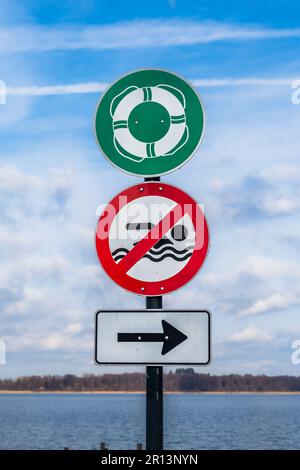 Segnali di avvertimento e informazione per bagnanti sulla riva di un lago Foto Stock