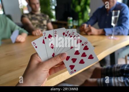Donna che gioca con le carte con gli amici primo piano . Foto Stock