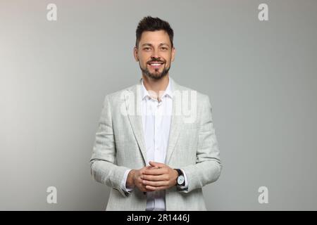 Insegnante felice in tuta leggera su sfondo beige Foto Stock