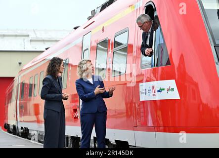 11 maggio 2023, Turingia, Erfurt: Susanna Karawanskij (Die Linke, M), ministro per le infrastrutture e l'agricoltura della Turingia, e Christine Singer (l), presidente della direzione regionale di DB Regio Südost, ispezionano il primo veicolo VT 612 riprogettato con Christoph Jentsch (r), ingegnere veicolo di DB Regio Südost, presso lo stabilimento di DB Regio. DB Regio sta attualmente modernizzando un totale di 36 vagoni ferroviari in tappe, che saranno utilizzati tra Göttingen e Glauchau, Erfurt e Altenburg/Greiz, Erfurt e Würzburg. I veicoli saranno dotati di accessori interni moderni, WLAN, prese USB e una nuova Foto Stock