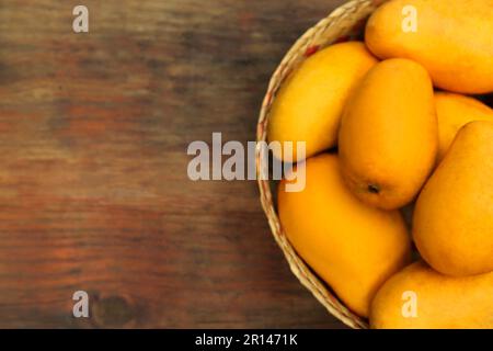 Deliziosi mango maturi e succosi su tavolo di legno, vista dall'alto. Spazio per il testo Foto Stock