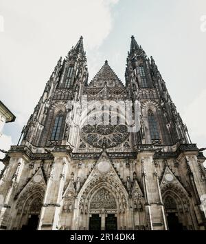 Vista a basso angolo della facciata gotica di St Cattedrale di Vito all'interno del complesso del Castello di Praga nella Repubblica Ceca. Foto Stock