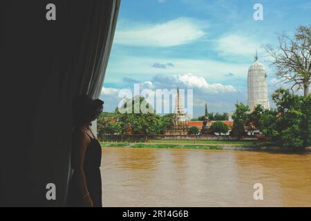 Attenzione selettiva alla donna che guarda Wat Phutthaisawan in Ayutthaya Historical Park, un sito patrimonio dell'umanità dell'UNESCO, Thailandia Foto Stock