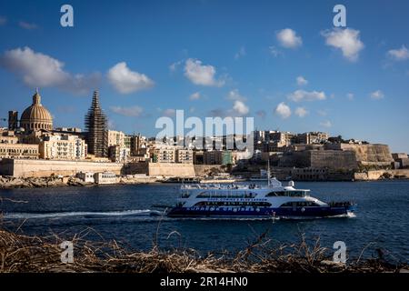 Valletta, Malta - 18 aprile 2023: Un panorama della città vecchia la Valletta, visto da Sliema. Battello turistico in primo piano. Foto Stock