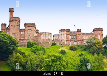Vecchio Castello di Inverness costruito di arenaria rossa su una collina verde in estate come visto dal fiume Ness. Scozia, Gran Bretagna, Europa. Foto Stock