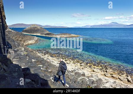 Isola di Staffa, Ebridi interne, Scozia - 14 giugno 2015: Turisti che camminano sulle famose formazioni rocciose esagonali dell'isola di Staffa lungo l'oceano. Foto Stock
