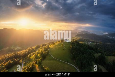 Veduta aerea della piccola chiesa sulla cima della montagna al tramonto Foto Stock