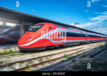 Treno rosso ad alta velocità in movimento sulla stazione ferroviaria Foto Stock