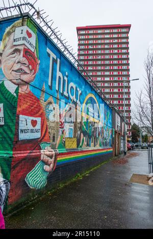 Murale all'angolo della strada con la Torre Divis sullo sfondo di Divis Street (la sezione inferiore della Falls Road) a West Belfast, Irlanda del Nord, Regno Unito Foto Stock