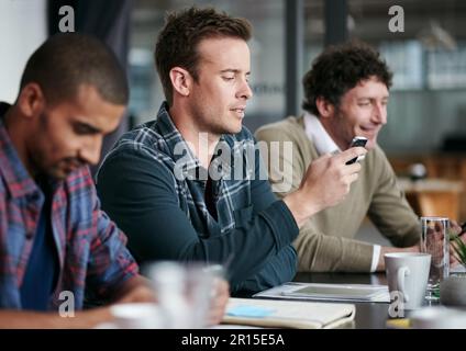 Lavorare nella sala riunioni. un gruppo di colleghi di sesso maschile che lavorano insieme alla scrivania di un ufficio. Foto Stock