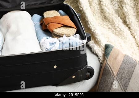 Valigia aperta con abiti femminili sul divano in soggiorno, guardaroba Foto  stock - Alamy