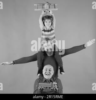 Generazione degli uomini: Nonno e nipote che giocano con l'aereo giocattolo. Ragazzo sogna di diventare pilota. Concetto di viaggio di viaggio. Isolato Foto Stock