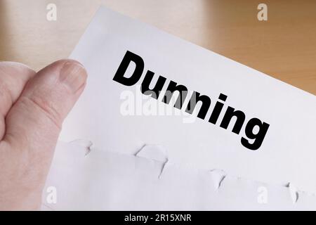 mano che tiene lettera dunning con busta aperta Foto Stock